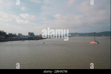 Bahia de Caraquez, Manabi / Ecuador - August 20 2022: Boote, die auf dem Chone Fluss fahren, mit einem Panoramablick auf die Stadt im Hintergrund bei Sonnen Stockfoto