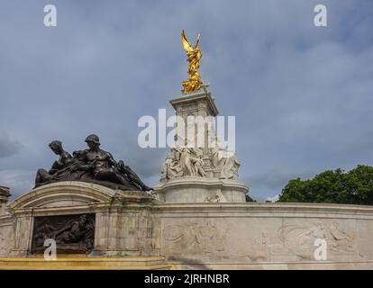 London, England, Großbritannien - 6. Juli 2022: Victoria Memorial. Kombinierte Aufnahme einer Statue eines Brunnenkuares mit einem angrenzenden Wandbild vor Queen, Truth und WI Stockfoto