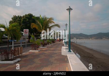 Bahia de Caraquez, Manabi / Ecuador - 20 2022. August: Menschen, die an einem bewölkten Tag auf der Strandpromenade der Stadt am Strand spazieren Stockfoto