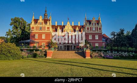 Eine wunderschöne Aufnahme von Schloss Muskau, umgeben von Bäumen, an einem wolkenlosen Tag in Bad Muskau, Deutschland Stockfoto