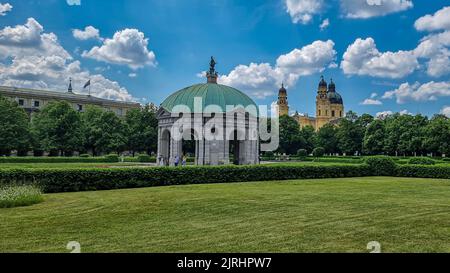 Eine schöne Aufnahme des Diana-Tempels im Münchner Hofgarten mit Theatinerkirche im Hintergrund Stockfoto