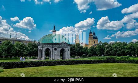 Eine schöne Aufnahme des Diana-Tempels im Münchner Hofgarten mit Theatinerkirche im Hintergrund Stockfoto