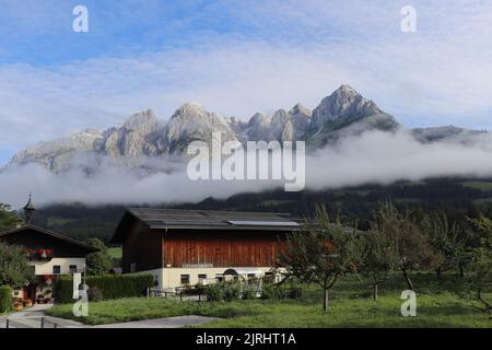 Landhaus in einer kleinen Stadt in Deutschland mit einer schönen Berge auf der Rückseite und den Wolken perfekt eine Linie auf dem Dach des Hauses. Ländliches Hotel Stockfoto