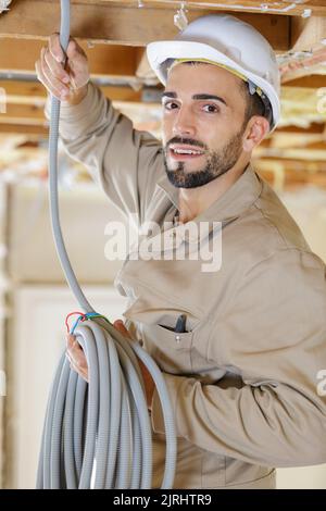 Porträt eines Handwerkers mit Kabelrolle Stockfoto