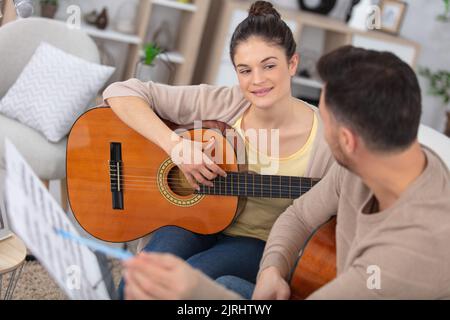 Gitarrenlehrerin, die ein Teenager-Mädchen unterrichtet Stockfoto