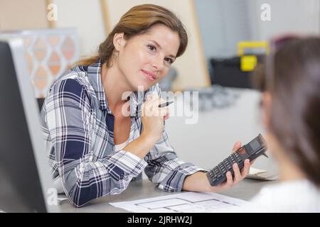 Junge Frau mit Rechner im Büro Stockfoto