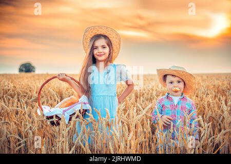 Schöne Mädchen Frau und Junge hält hausgemachtes Brot im Weizenfeld Stockfoto