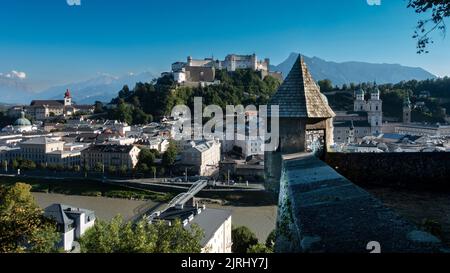 Faszinierende Aufnahme der schönen Stadtlandschaft entlang des Flusses und der mittelalterlichen Burg Hohensalzburg in Salzburg, Österreich Stockfoto