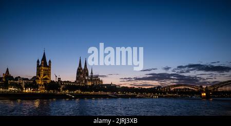 Landschaftsbild der Martinskirche und des Kölner Doms am Abend mit der Hohenzollernbrücke im Hintergrund Stockfoto