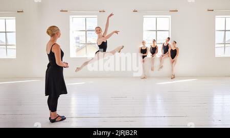 Ballettlehrer, Tanzschüler und Studio mit Gruppenvielfalt von Ballerina-Tänzern in kreativem Theater Jump-Performance. Theatersaal, Kunst oder Stockfoto