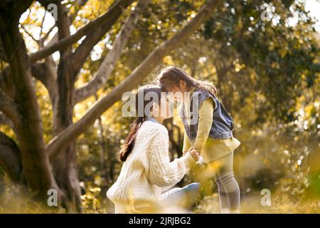 Junge asiatische Mutter und Vorschultochter genießen die Natur mit einer guten Zeit im Park Stockfoto