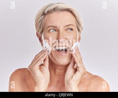 Ältere Frau Hautpflege und Gesicht mit Produkt-Entferner und Make-up-Reinigung oder Beauty-Modell mit kosmetischen Baumwollpads auf Studio Mockup Hintergrund. Glücklich Stockfoto