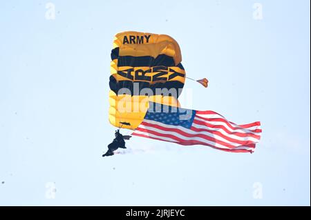 24. August 2022: 24. August 2022, Atlantic City NJ- Ein Golden Knight der US Army, der während der Donner over the Boardwalk Air Show die amerikanische Flagge über dem Strand von Atlantic City trägt (Foto: © Ricky Fitchett/ZUMA Press Wire) Stockfoto