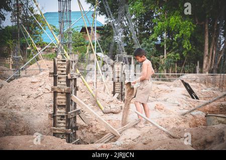 Arme Kinder, die auf der Baustelle gegen Kinderarbeit arbeiten, Kinder müssen wegen Armut arbeiten, Welttag gegen Kinderarbeit und tra Stockfoto