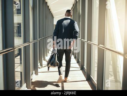 Ein Geschäftsmann am Flughafen, der auf Geschäftsreise ist, und ein afrikanischer Mann am Morgen pendeln in die Stadt. Transport Service vom Flugzeugterminal zum Hotel, Rückansicht Stockfoto