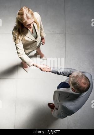 Gemeinsam den Wert des Geschäfts steigern. Aufnahme von zwei Geschäftsleuten, die sich in einem Büro die Hände schüttelten. Stockfoto