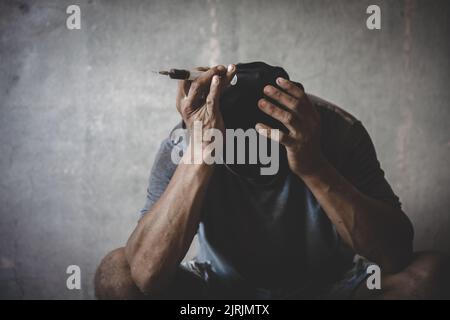 Drogenabhängiger Mann mit Halluzinationen, drogenabhängiger Mann mit Spritze, der Drogen verwendet. Stockfoto