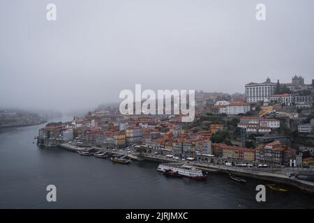 Porto, Portugal. 24. August 2022. Blick auf die Porto Riviera und den Douro Fluss bei nebeligem und bewölktem Wetter. Nach Angaben des portugiesischen Instituts für Meer und Atmosphäre (IPMA für seine Abkürzung auf Portugiesisch) wird aufgrund einer drastischen Wetteränderung während der Hochsommer ein gelber Alarm ausgegeben. Die Wetterlage betrifft einen Teil der iberischen Halbinsel aufgrund einer Depression thermischer Herkunft, die Stürme und Hagel verursachen könnte. Kredit: SOPA Images Limited/Alamy Live Nachrichten Stockfoto