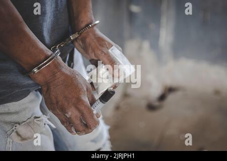 Drogenhändler wurden zusammen mit ihrem Heroin verhaftet. Die Polizei verhaftete Drogenhändler mit Handschellen. Gesetz- und Polizeikonzept, 26. Juni, International Da Stockfoto