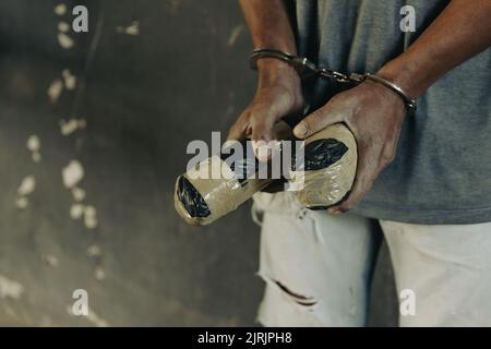 Drogenhändler wurden zusammen mit ihrem Heroin verhaftet. Die Polizei verhaftete Drogenhändler mit Handschellen. Gesetz- und Polizeikonzept, 26. Juni, International Da Stockfoto