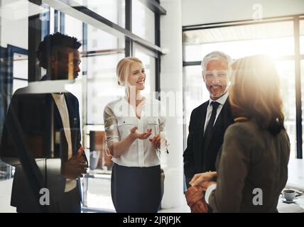 Feedback vom Team. Vier Geschäftsleute sprechen im Büro. Stockfoto