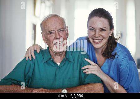 Ich Sorge dafür, dass sie sich um sie kümmert. Eine Krankenschwester, die neben ihrer älteren Patientin steht. Stockfoto