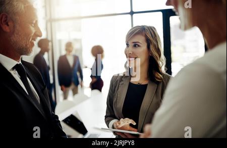 Ist ein großer Gewinn für das Unternehmen. Drei Geschäftsleute sprechen im Büro. Stockfoto