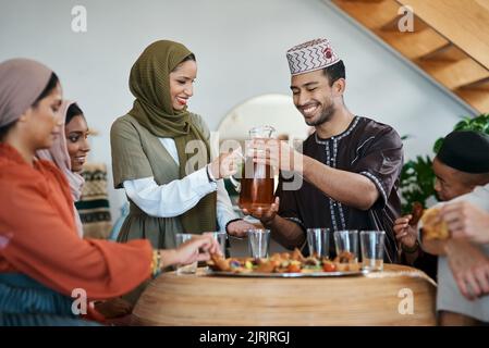 Ramadan, Eid und Iftar mit einer muslimischen Familie, die das Fastenbrechen mit Essen und Trinken zu Hause zelebriert. Sich verbinden, zusammen fühlen und genießen Stockfoto