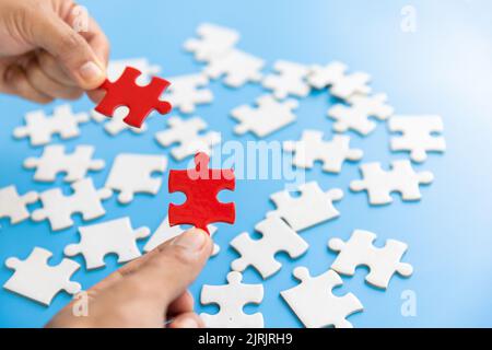 Menschliche Hände halten rote Puzzle mit Wort Problem & Lösung. Symbol für Vereinigung und Verbindung. Geschäftsstrategie. Stockfoto