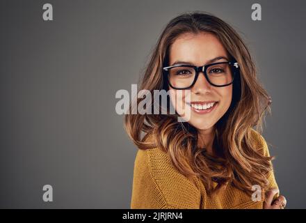 Respektieren Sie die Spezifikationen. Studioportrait einer attraktiven jungen Frau, die vor grauem Hintergrund posiert. Stockfoto