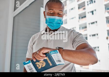 Covid, Einwanderungs- und Passmann mit Gesichtsmaske für Corona-Virus und Reisebeschränkungen oder Verspätung am Flughafen. Schwarzer Mann, der Zeit überprüft und zu spät kommt Stockfoto