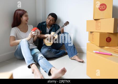Paar halten Modellhaus, neues Haus in der Hand und den Kauf eines neuen Hauses und Umzug zusammen Geschäft und Immobilien-Konzept. Stockfoto