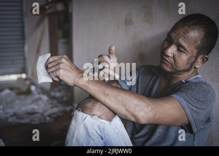 Drogenabhängiger Mann, der Heroin in seinen Arm injiziert, Drogenabhängiger Mann mit Spritze, Drogen-Konzept, 26. Juni, Internationaler Tag gegen Drogenmissbrauch Stockfoto