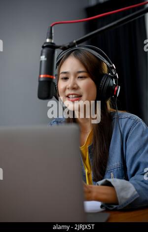 Portrait, Professionelle junge asiatische weibliche Podcaster macht einen Podcast aus dem Home Studio. Frau, die von zu Hause aus einen Podcast mit professionellen E-Aufnahmen aufzeichnete Stockfoto