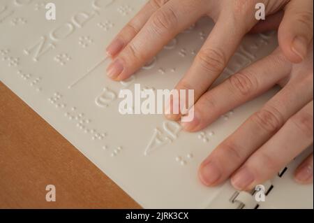 Eine Frau lernt das Braillealphabet mit einem Decoder. Stockfoto