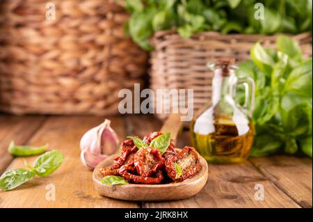 Getrocknete Tomaten mit Kräutern und Olivenöl. Traditionelle Tomaten aus der Dose in Italien mit Knoblauch, Kräutern der Provence und Basilikum. Zutaten für Bruschetta und Aperitif. Draufsicht, Platz für Text Stockfoto