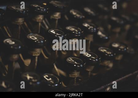 Klassische Schreibmaschine. Eine Reihe von Schlüsseln einer altmodischen Schreibmaschine. Retro-Stil des Schreibens. Buchstaben auf Knöpfen. Nostalgiekonzept. Konzept des Geschichtenerzählens. Stockfoto
