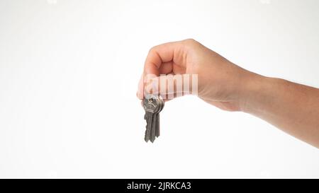 Die Hand eines Mannes hält mit den Fingern einen Schlüsselbund. Hochwertige Fotos Stockfoto