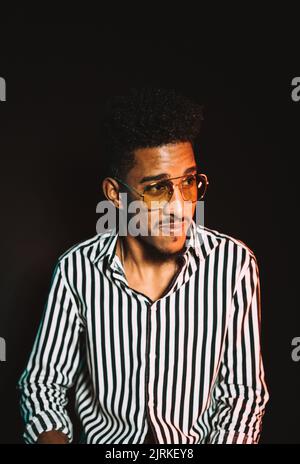 Porträt eines jungen afroamerikanischen männlichen Mannes in stilvoller Kleidung und Brille Stockfoto