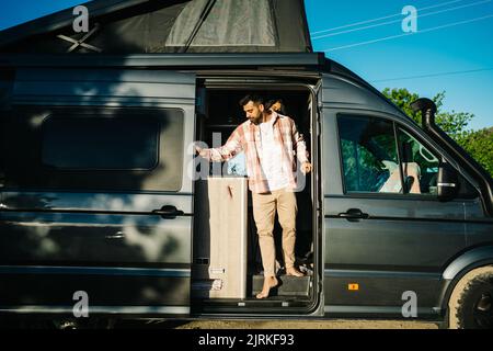 Ein paar Reisende stehen in geparkten Wohnmobil in der Natur an sonnigen Tag im Sommer Stockfoto