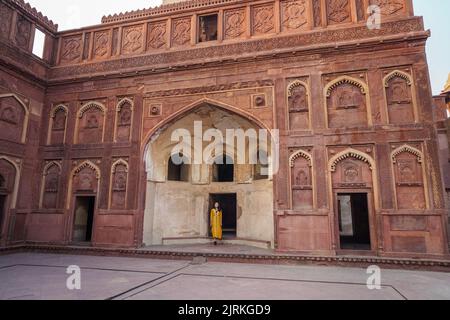 Ganzkörperfrau in gelbem Kleid, die im Bogen des Agra Fort in Uttar Pradesh, Indien, steht Stockfoto