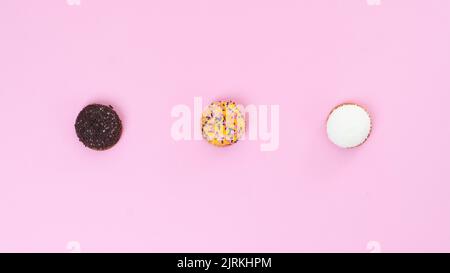 Drei Kuchen auf einem rosa Hintergrund. Hochwertige Fotos Stockfoto