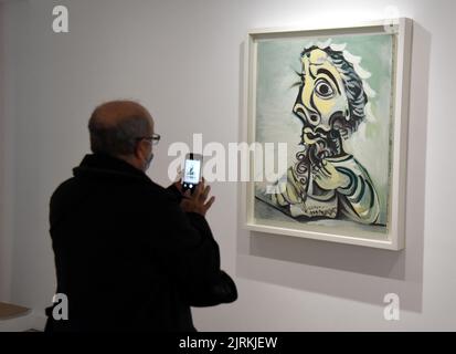 Paris (Frankreich): Das Picasso-Museum im 3.. Arrondissement. Mann, der mit seinem Smartphone ein Bild eines Gemäldes macht, „Bust of man Writing“ Stockfoto