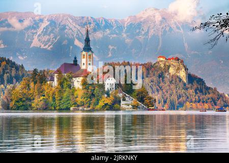 Atemberaubende Aussicht auf den Sonnenuntergang über dem beliebten Touristenziel Bled See. Dramatische Ansicht der Wallfahrtskirche Mariä Himmelfahrt. Lage: Bled, Uppe Stockfoto