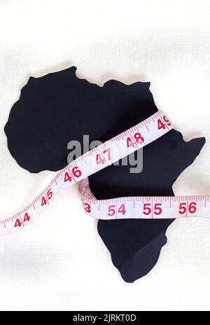 Schwarz geschnitten aus Afrika Kontinent auf weiß mit Maßband umwickelt Stockfoto