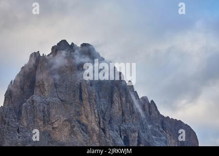 Atemberaubende Luftaufnahme der Dolomitenalpen bei sonnigem Herbsttag mit gelben Lärchen unten und Tal bedeckt von Nebel und hohen Berggipfeln dahinter. Corti Stockfoto