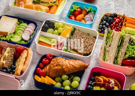 Verschiedene gesunde Lunchboxen. Pack für die Schule Set in Kunststoff-Paket Stockfoto