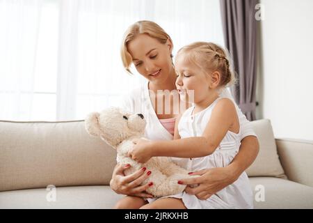 Mutter und Tochter spielen mit Teddybär Stockfoto