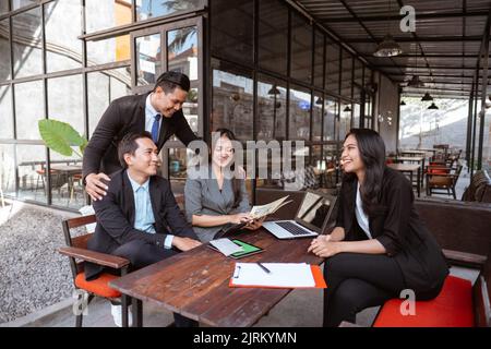 asiatischer Arbeiter während einer Pause beim Treffen im Café Stockfoto