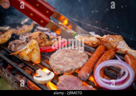 Verschiedene köstliche gegrillte Fleisch mit Gemüse über den Kohlen auf einem Grill Stockfoto